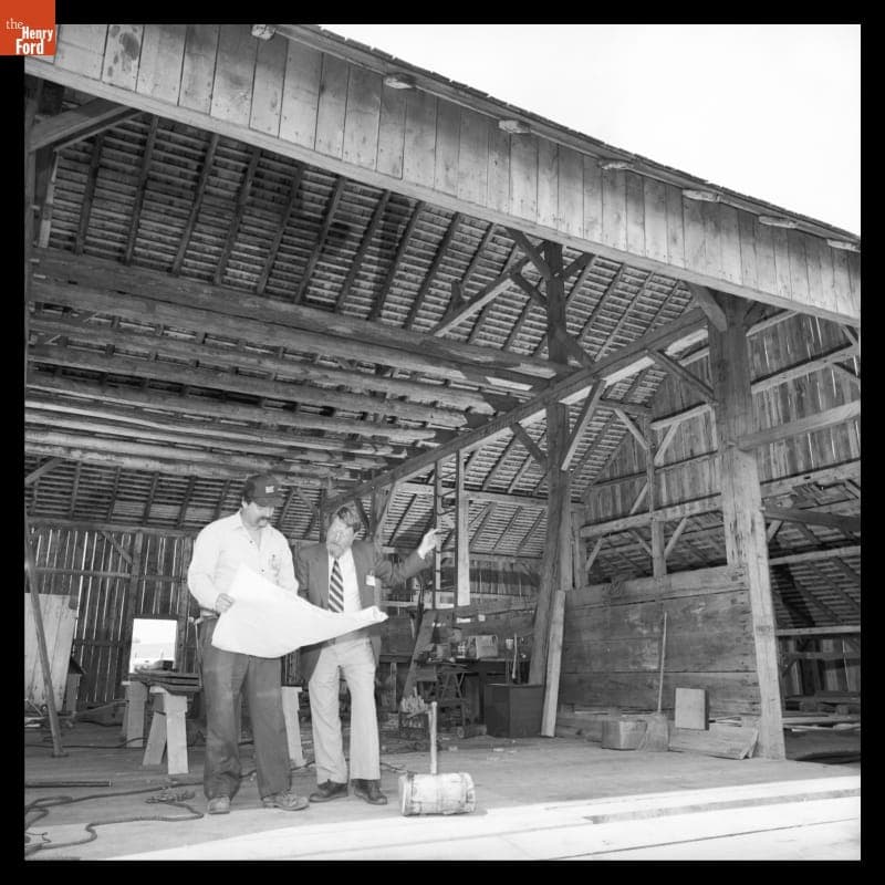 Carpenter Dave Shockley and Project Director Peter Cousins Study Plans in the Partially Reconstructed Firestone Barn, May 1985