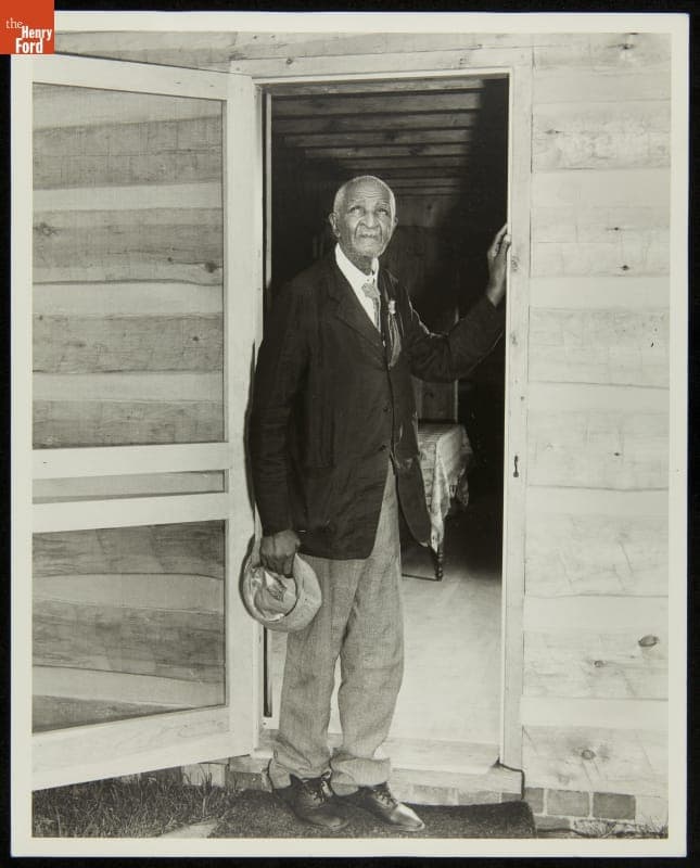 George Washington Carver in Doorway of the George Washington Carver Cabin, Greenfield Village, 1942