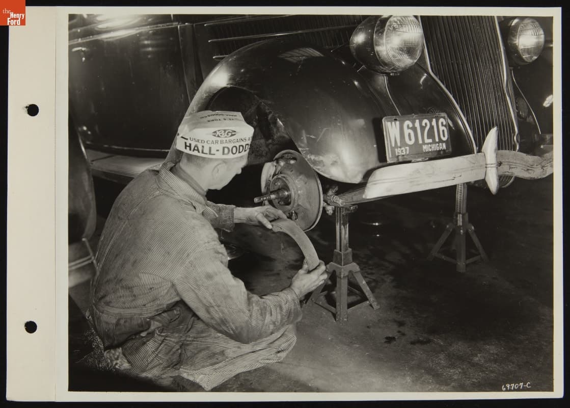 Mechanic Repairing Used Car Wheel at Hall-Dodds Dealership, January 1938