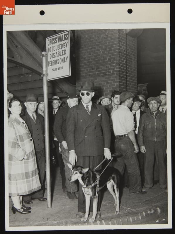 Ford Employee Sylvester Rypkowski with Service Dog "Blackie," Waiting at Cross Walk, October 1942