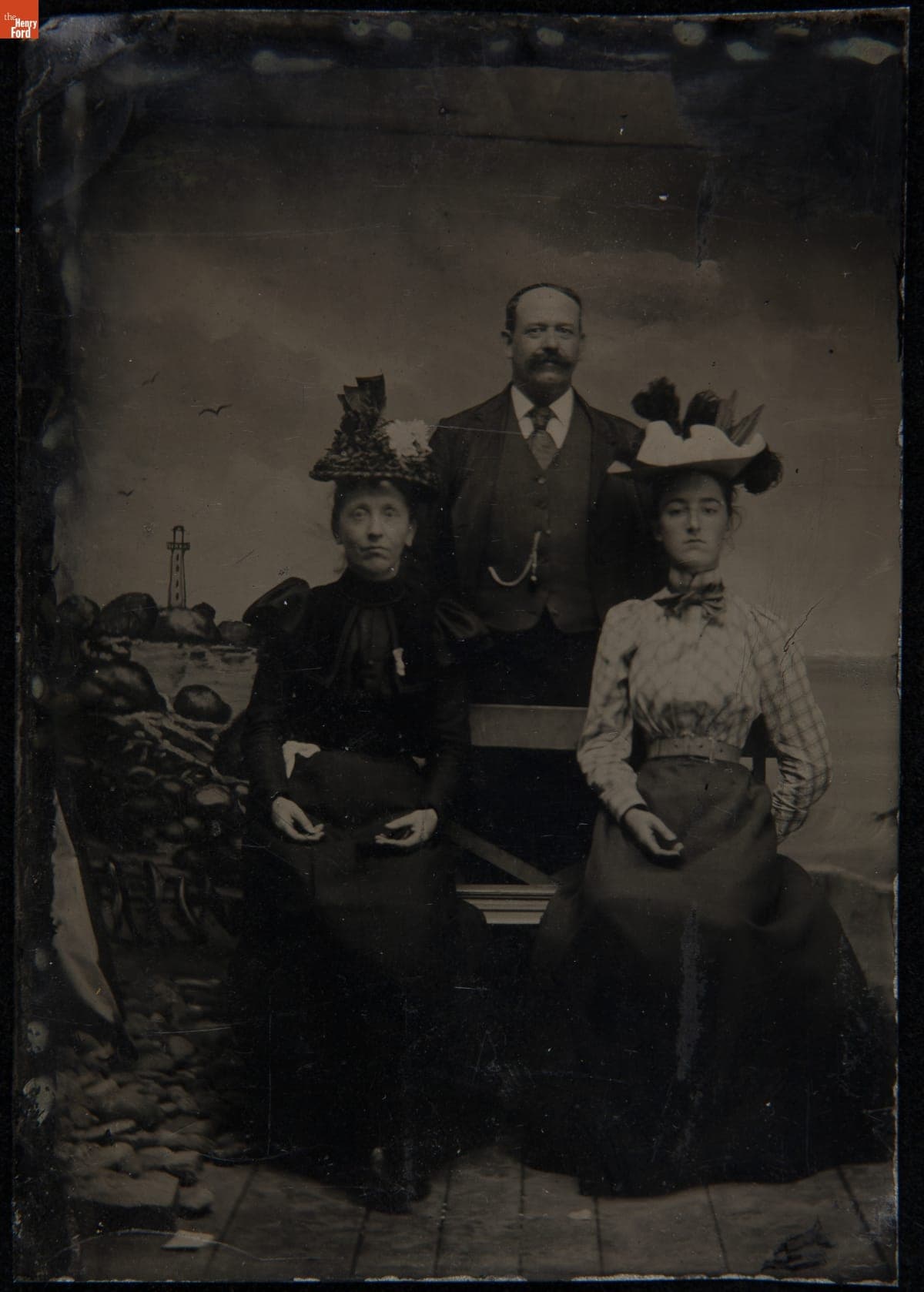 Two Women and a Man in Front of a Painted Seashore Backdrop, 1890-1899