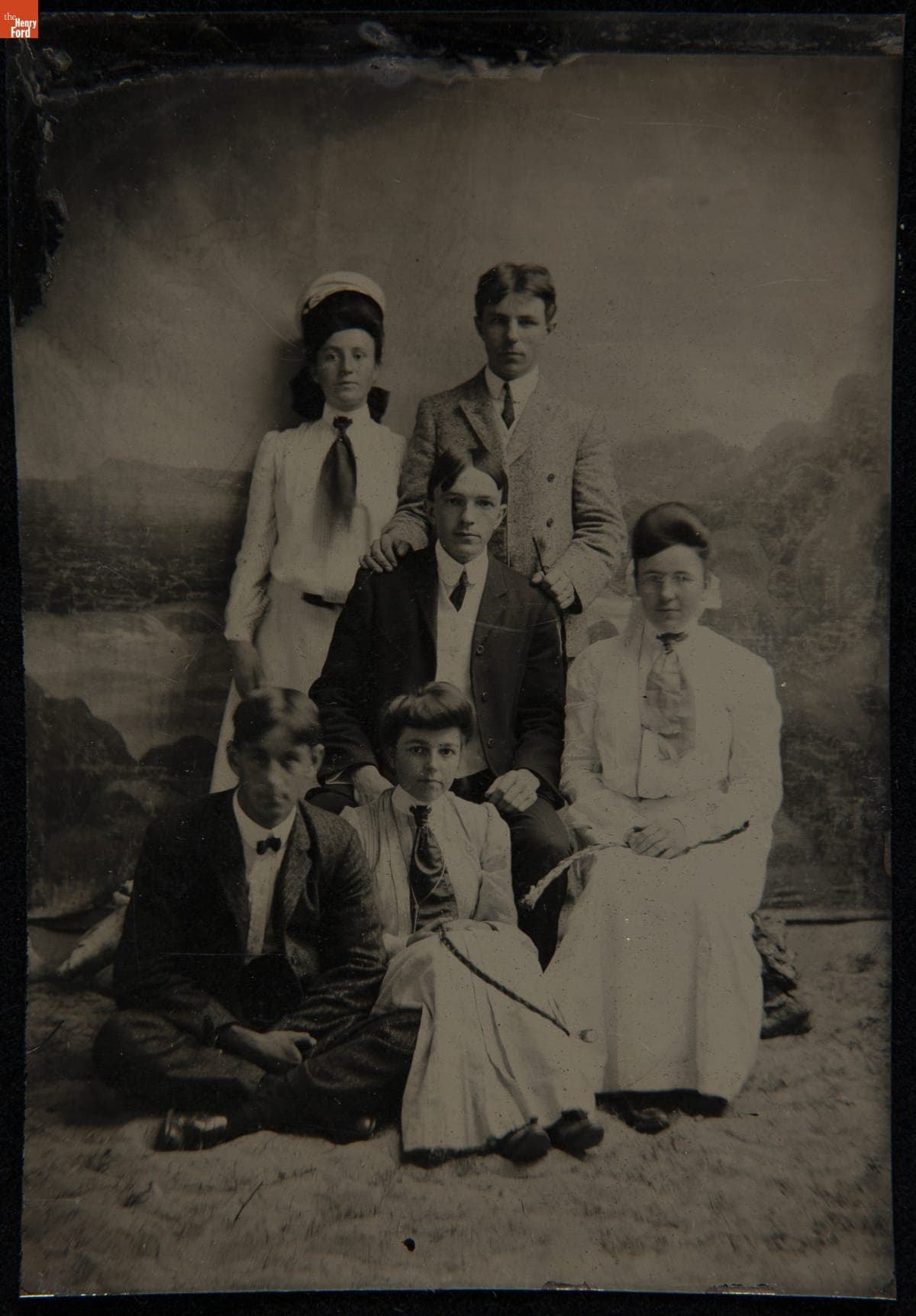 Three Men and Three Women Pose in Front of a Painted Backdrop, circa 1910