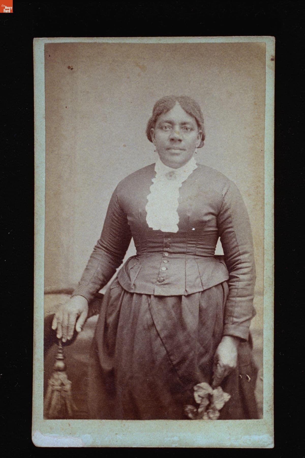 Woman wearing a White Lace Collar and Holding a Flower, circa 1880