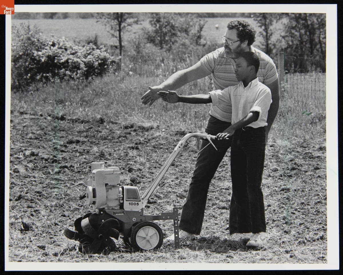 Agriculture Specialist Mike Reed Instructs Student Joseph Johnson in Preparing Soil for Cucumber Planting, June 1985