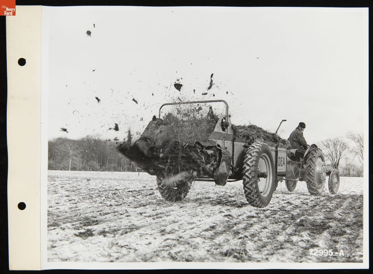 Man Driving a Ford Ferguson Tractor Pulling a Trailer of Manure to Spread over a Field, January 1940