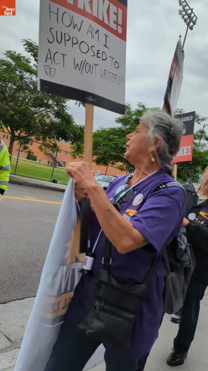 Writers Guild of America Strike Picketer Holding Sign that Reads "How Am I Supposed to Act without Writers?," June 3, 2023