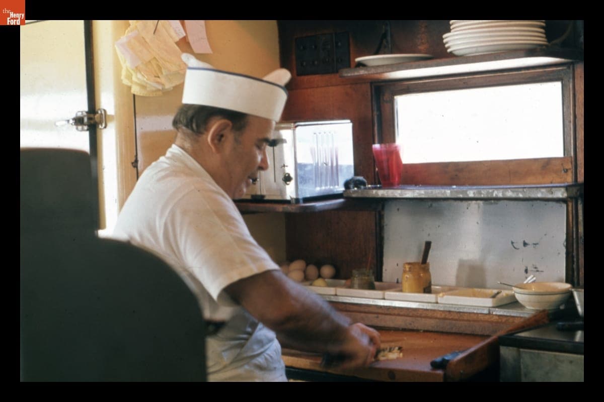Black & Gold Diner Owner Jimmie Limperopoulis Cooking for Customers, circa 1973