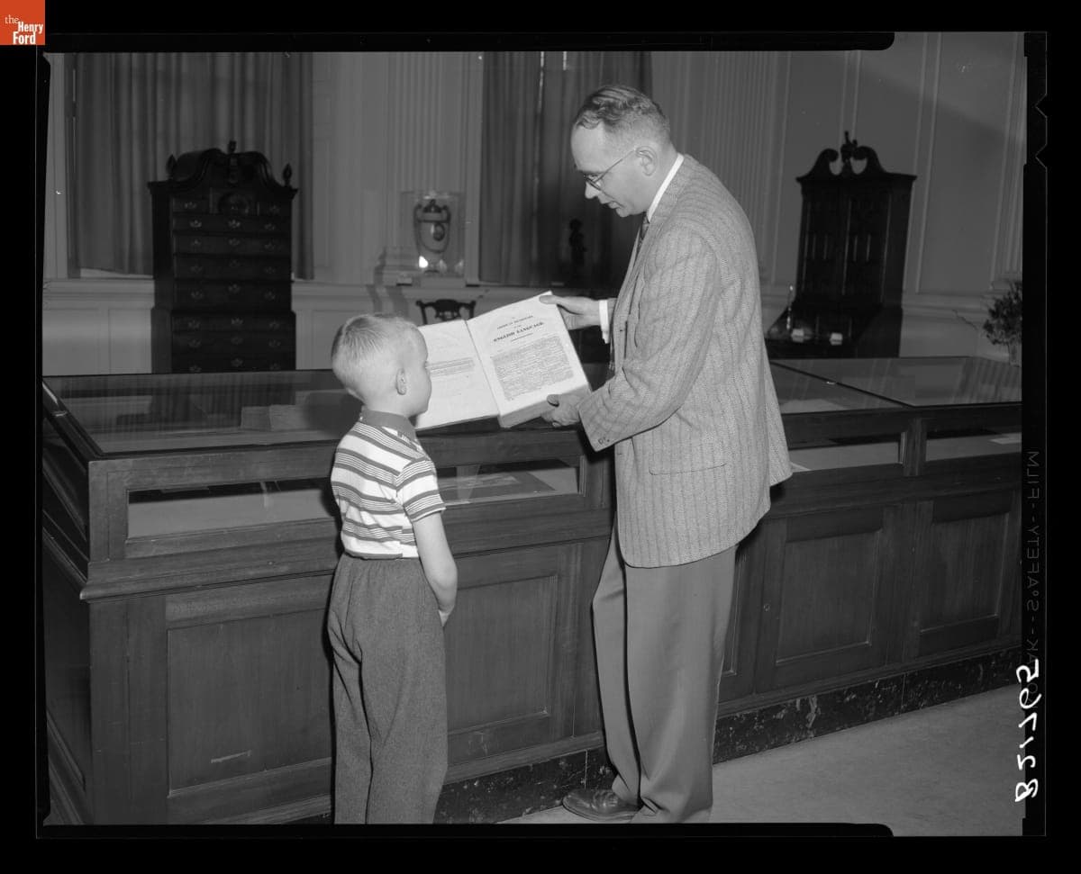 Librarian Ken Metcalf and Son Mark Viewing an 1828 Webster Dictionary on Exhibit during National Library Week, April 8, 1959