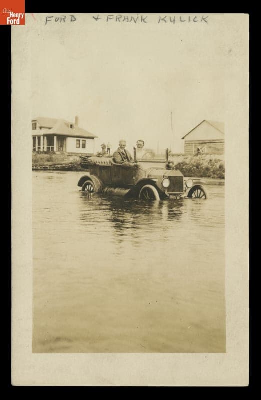 Henry Ford and Frank Kulick Seated in a Ford Model T during a Flood, circa 1916
