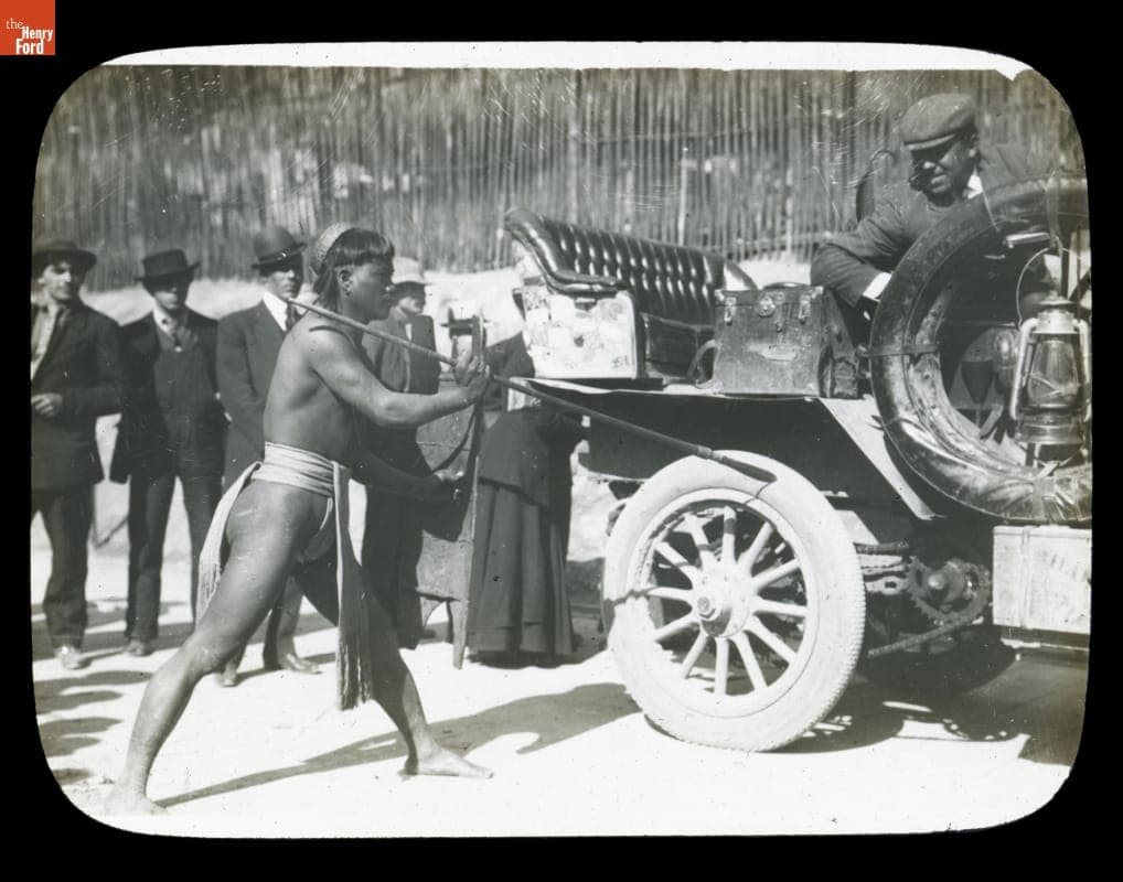 Man Holding Spear to Thomas Flyer Tire in Seattle, Washington, on Pathfinder Tour before the New York to Seattle Race, 1909