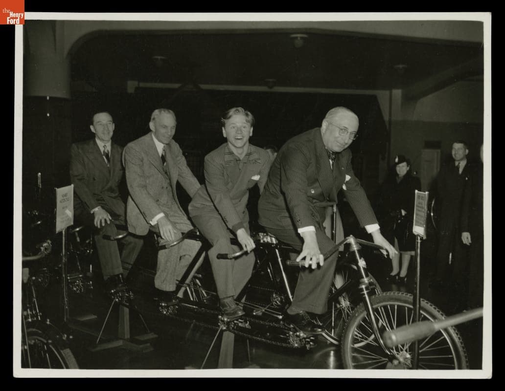 Edsel Ford, Henry Ford, Mickey Rooney and Louis B. Mayer on the 10-Man Orient "Oriten" Bicycle in Henry Ford Museum, 1940