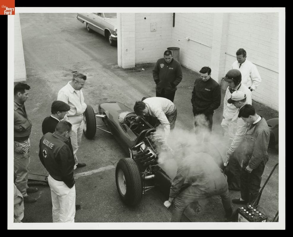 Dan Gurney, Colin Chapman and Mechanics with Smoking Engine, Lotus Ford Test, February, 1963