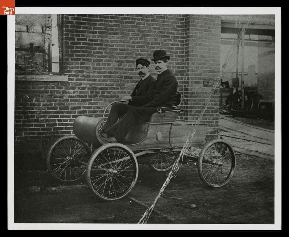 Engineers M. S. Loomis and C. Wilson in Curved-Dash Oldsmobile outside Olds Motor Works Factory, Detroit, Michigan, 1901
