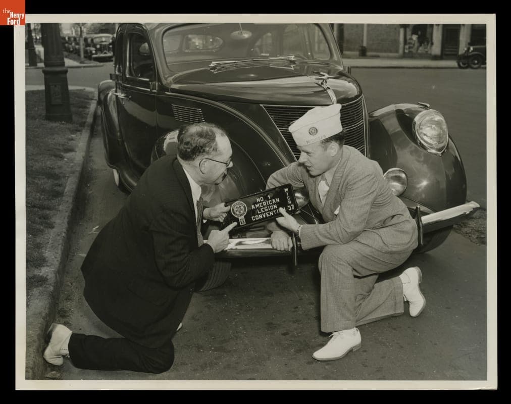 Michigan Secretary of State Leon Case and Guy Cox with an American Legion License Plate, 1937