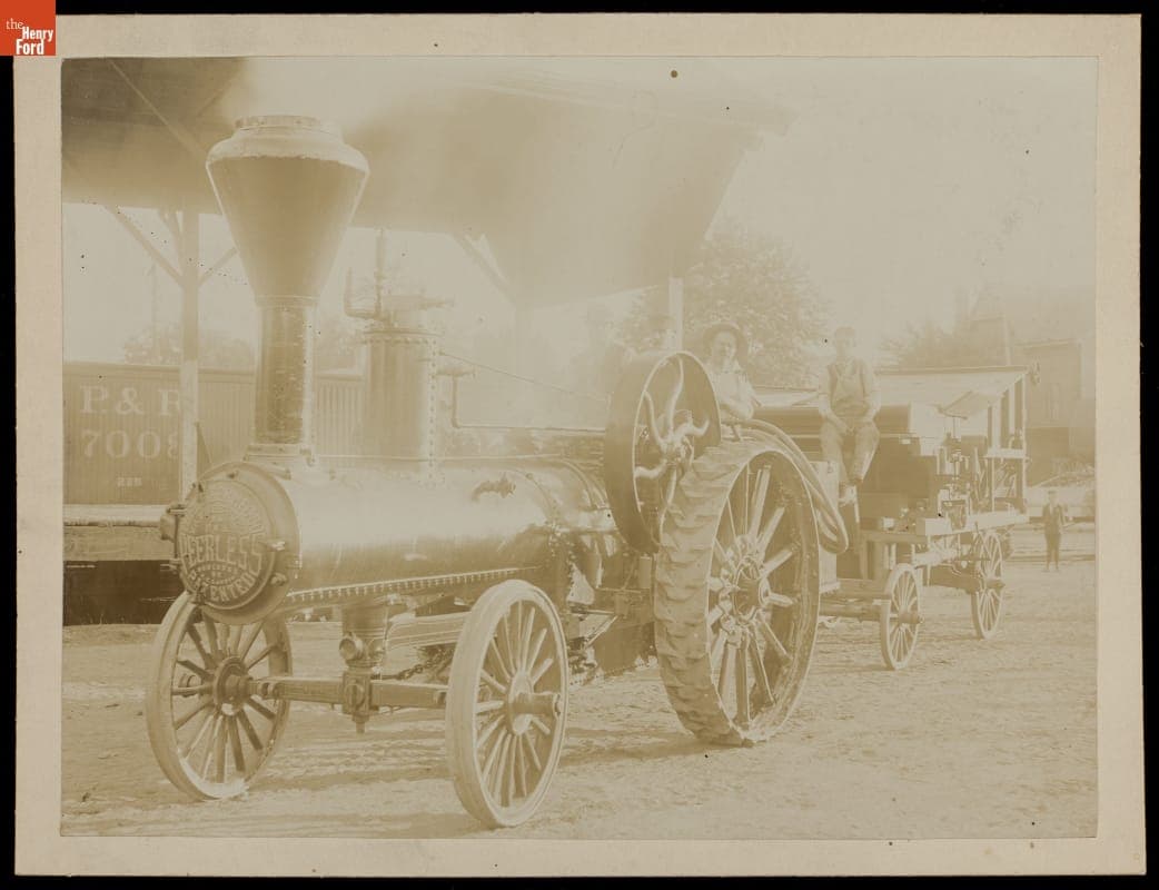 Engineer and Fireman aboard Peerless Traction Engine, Pulling Grain Separator, 1896