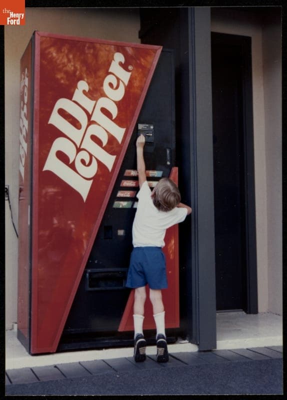 Young Boy Reaching to Use a Soda Vending Machine, 1990