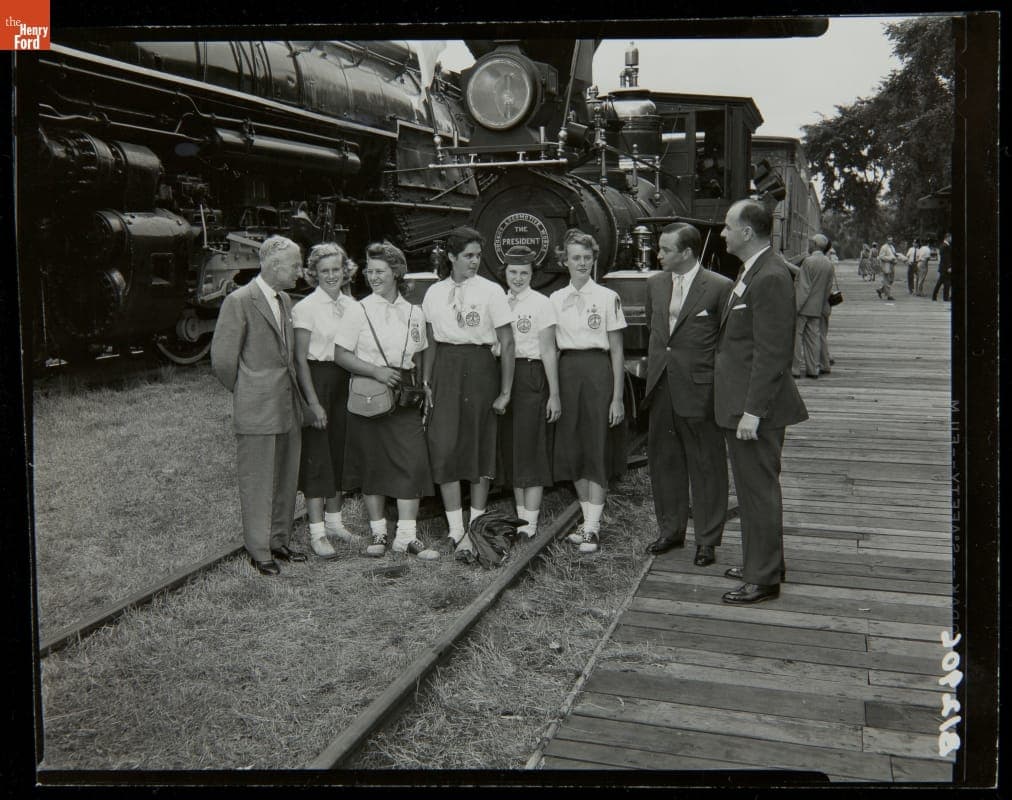Walter Tuohy, William Clay Ford and Donald Shelley with Girl Scouts at the Allegheny Locomotive Presentation, Greenfield Village, July 1956