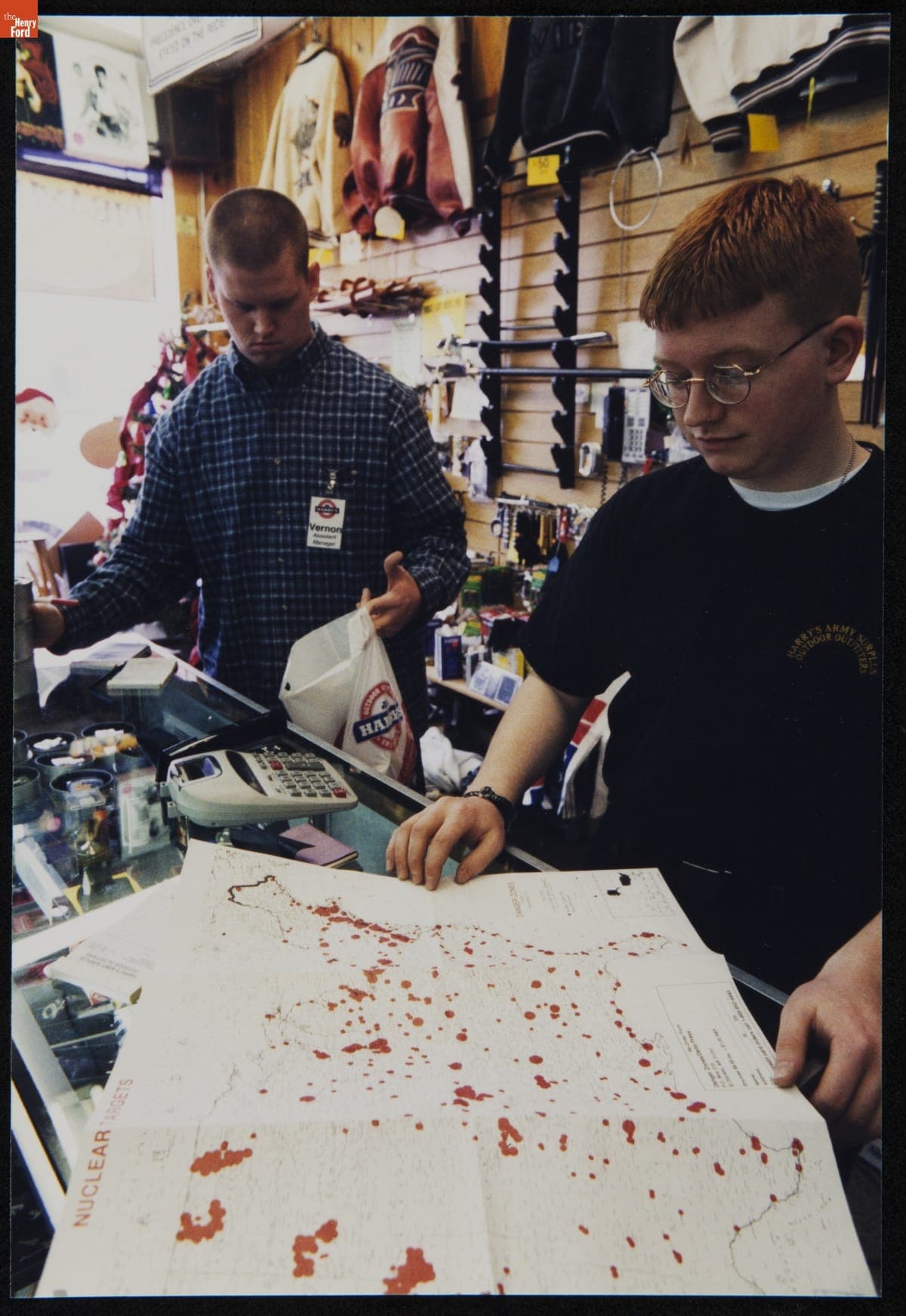 Employees at Harry's Army Surplus Holding a Map, December 31, 1999