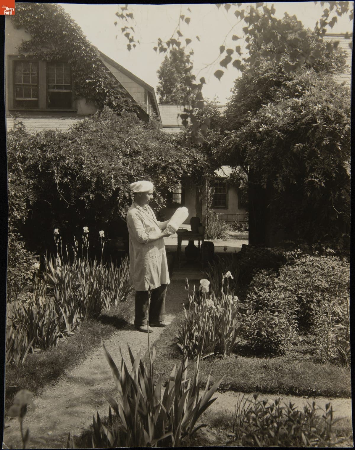 A Man Holds a Piece of Pottery in the Garden of the Paul Revere Pottery, 1930-1936