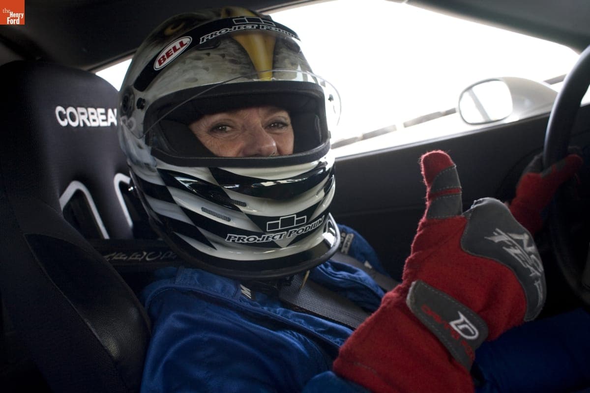 Lyn St. James Suited Up in Racecar Giving a "Thumbs-Up," 2008