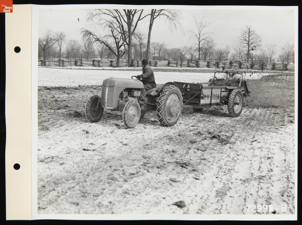 Man Driving a Ford Ferguson Tractor Pulling a Trailer of Manure to Spread over a Field, January 1940