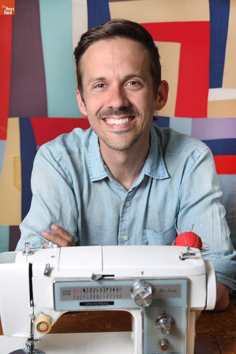 Zak Foster Sitting at a Sewing Machine, May 2021