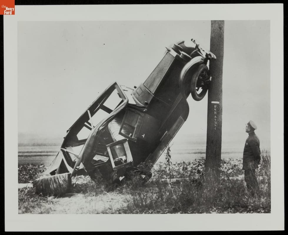 Officer Observing Car Leaning Against Utility Pole, circa 1920