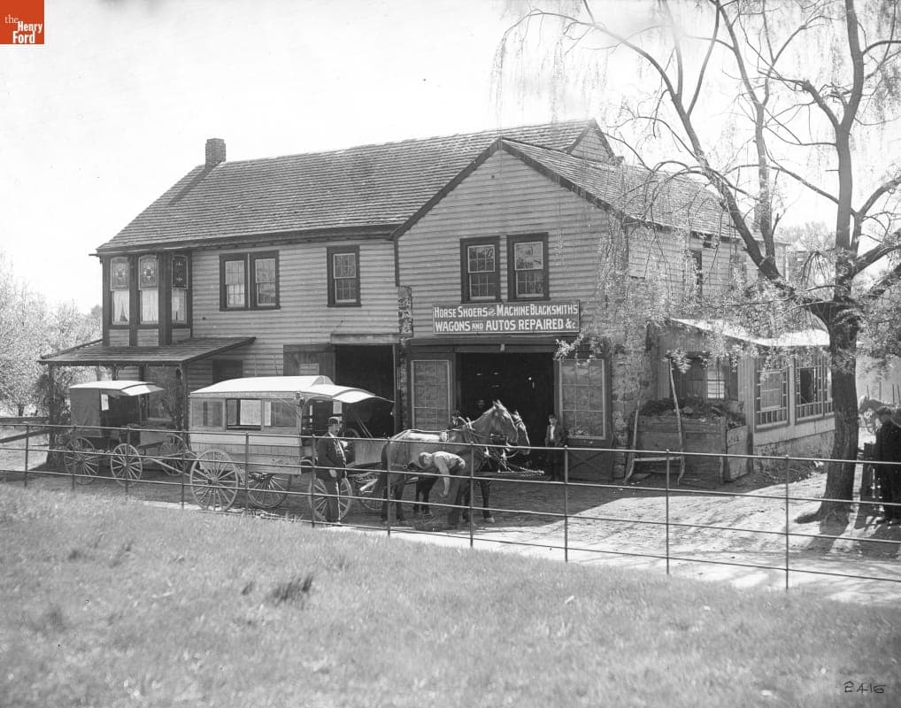 Building with Sign "Horse Shoers and Machine Blacksmiths, Wagons and Autos Repaired," circa 1900