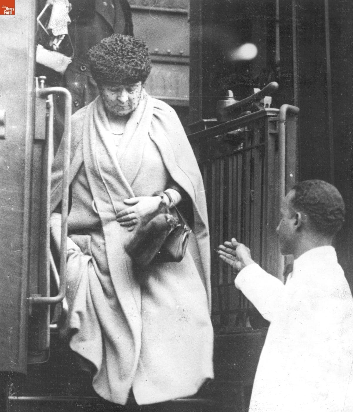 Porter Assisting Clara Ford as She Steps Down from a Train, circa 1940