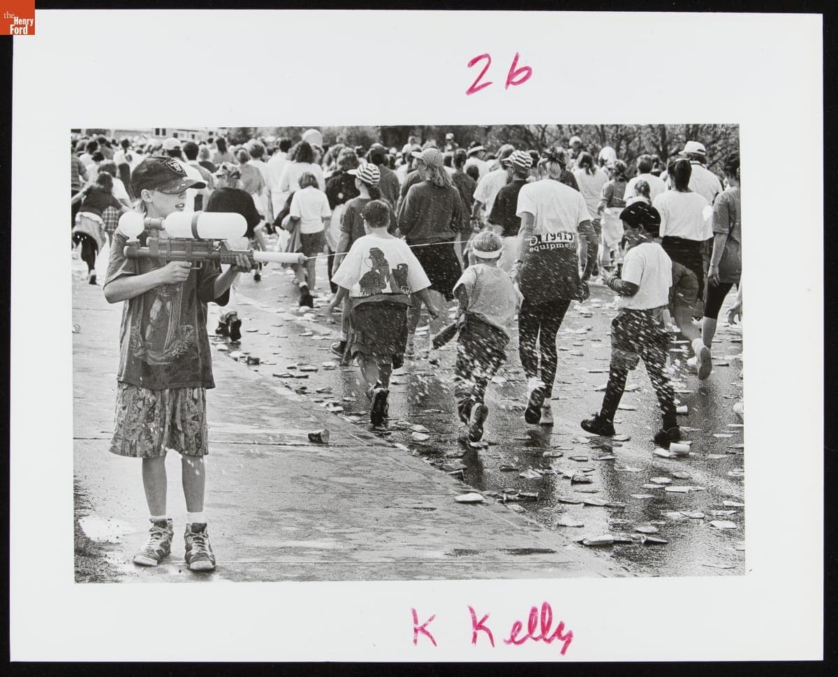 Boy Using a Super Soaker to Cool Bloomsday Road Race Runners, Spokane, Washington, May 1993