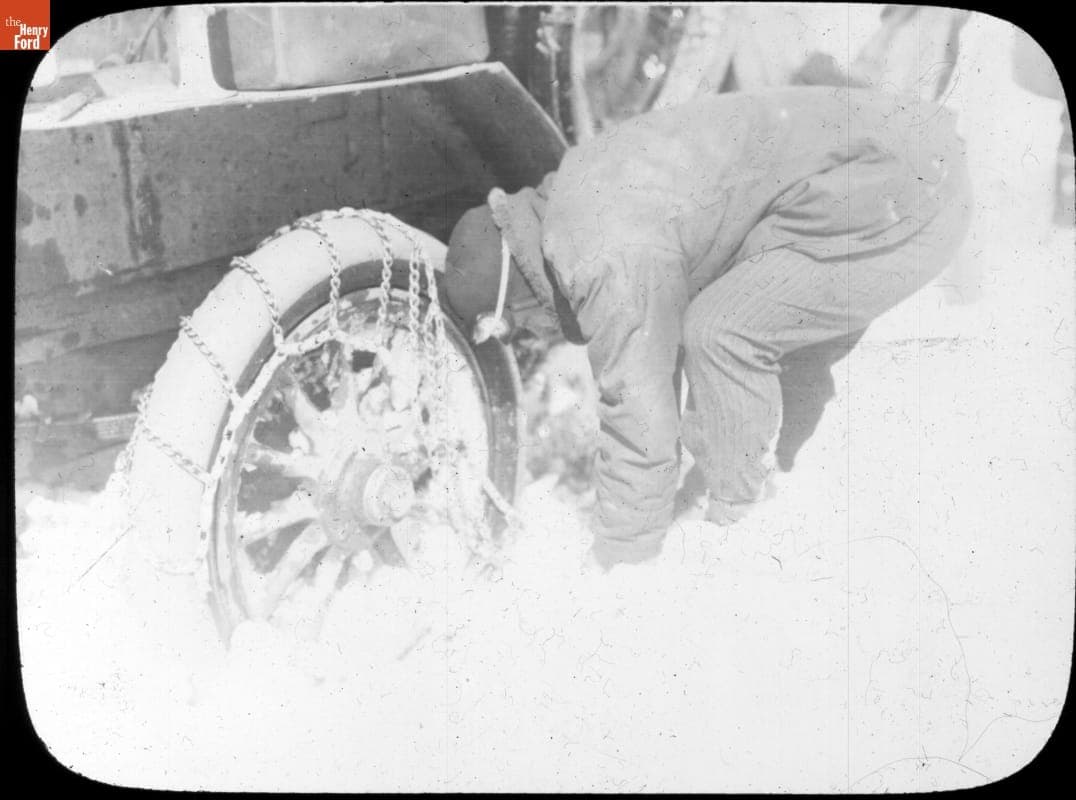 Putting Snow Chains On a Tire during the New York to Paris Race, 1908