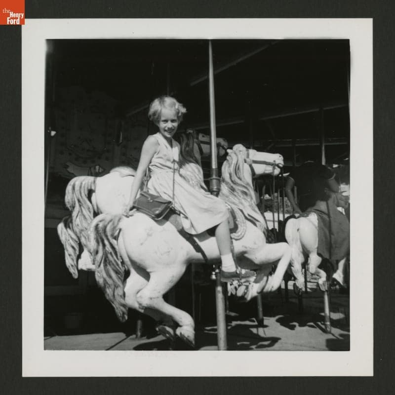 Young Girl Seated on a Carousel Horse, circa 1955