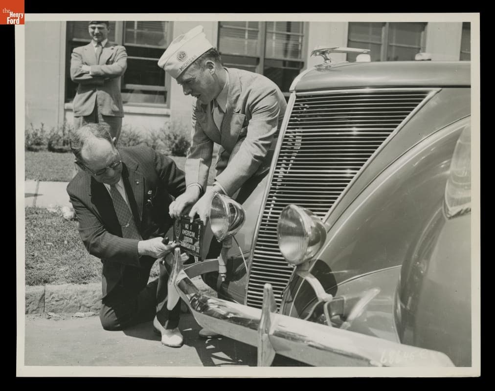 Michigan Secretary of State Leon Case and Guy Cox Affix an American Legion License Plate, 1937