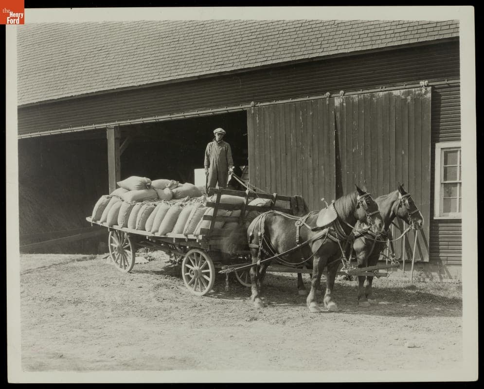 Farmer on a Loaded Wagon outside Barn, circa 1925