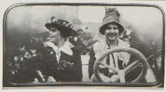 Two women in car, woman behind wheel looking at camera, woman in passenger seat looking to her right