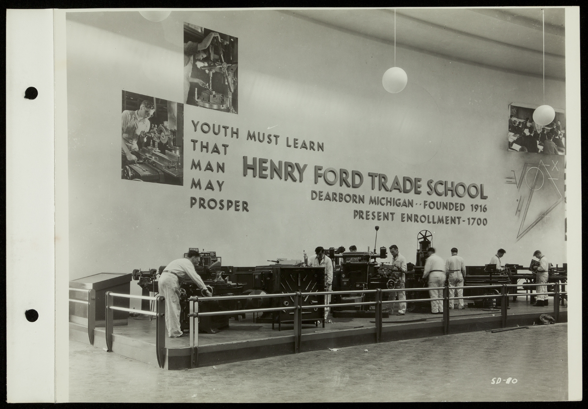 Henry Ford Trade School Demonstration, California Pacific International Exposition, San Diego, 1935 Boys/young men work at a variety of machinery under a wall containing images and text