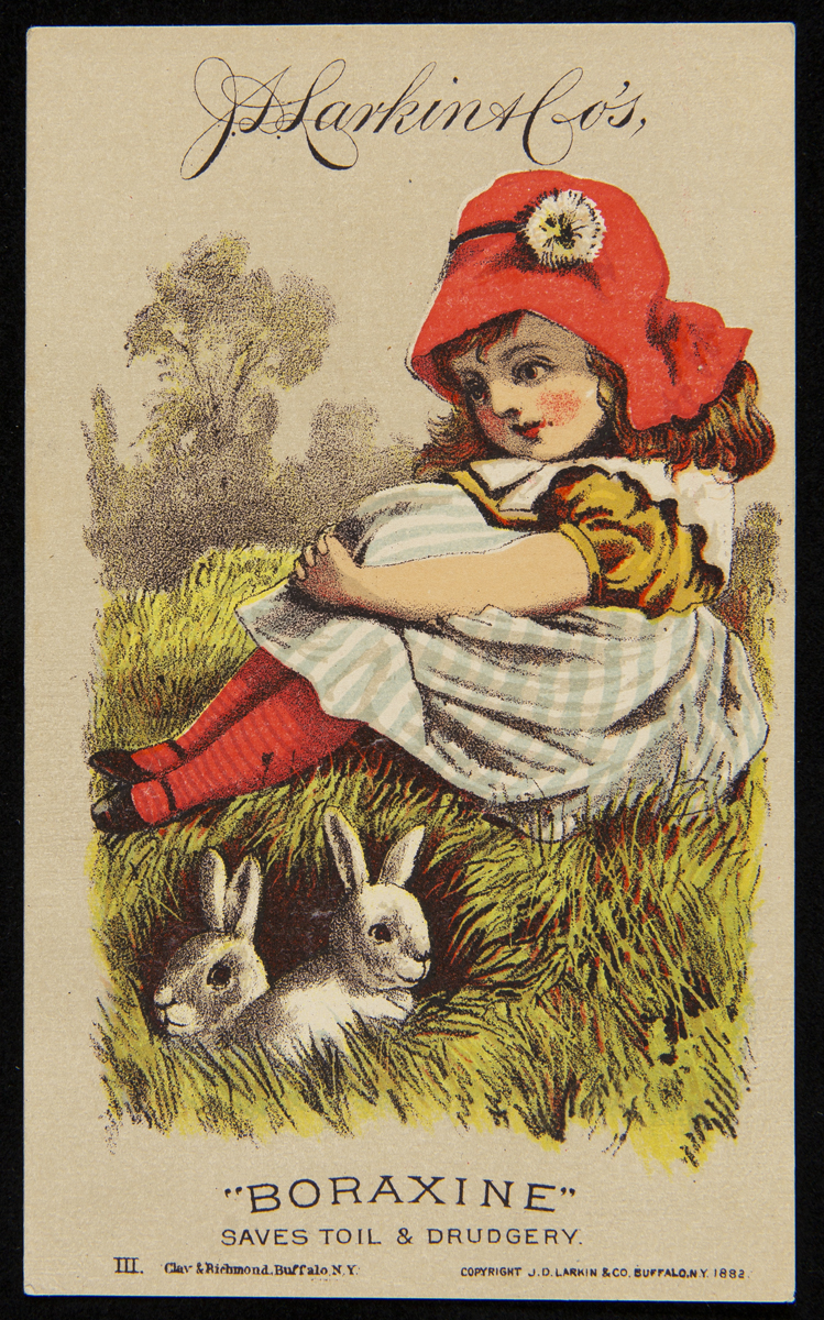 Card with drawing of young girl wearing red hat, red tights, blue checked dress, sitting on grass with two white rabbits nearby; also contains text