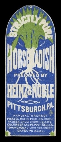 Blue arch-shaped label with white text and white and green image of plant with roots