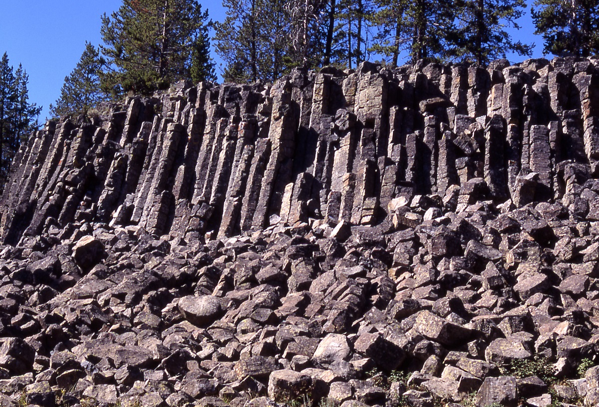 Sheepeater Cliff, Yellowstone National Park Angular, geometric rock cliff with loose rocks covering slope below