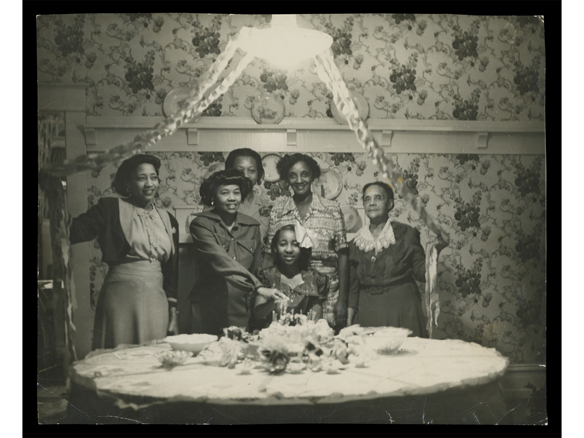 Birthday party for Rose Marie Foster (seated) hosted by Mrs. Bennie Portlock (directly behind Rose). This ca.circa 1953 image shows the original features of the dining room and some of Mrs. Portlock’s floral wallpaper. Marie Foster, one of Selma’s “Courageous Eight,” stands next to her daughter, Rose.  Marie was the sister of Sullivan Jackson and worked as a dental hygenist for both Dr. Portlock and Dr. Jackson.
