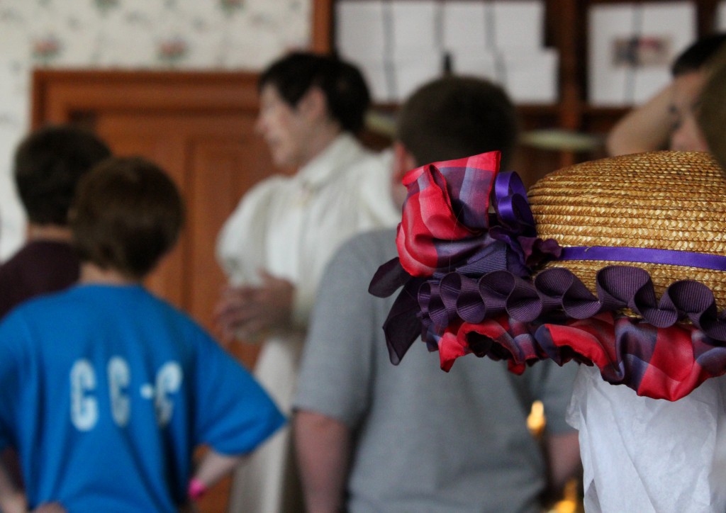 The presenter tells some visitors about the shop - Mrs. Cohen's Millinery, Greenfield Village
