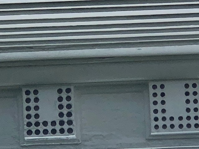 Architectural elements of white boxes with round holes in a "U" pattern in them