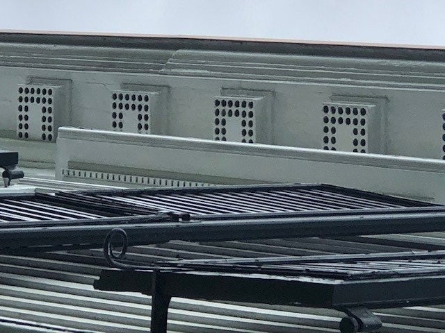 Architectural elements of white boxes with round holes in a "U" pattern in them