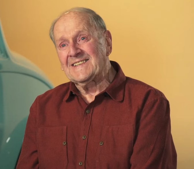 Portrait of seated man in maroon-colored shirt