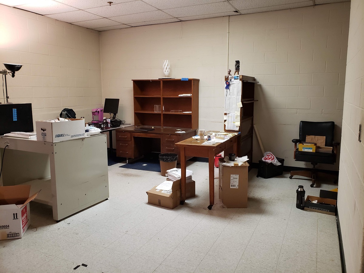 Room containing desks, shelves, chair, and boxes