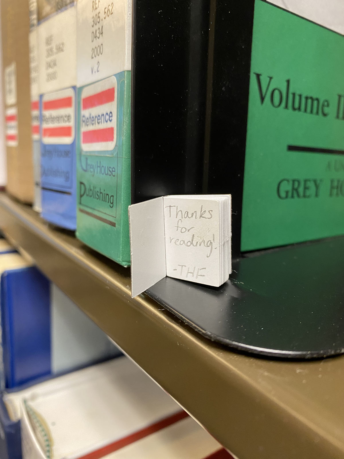 a tiny book opened to the front page that reads thanks for reading