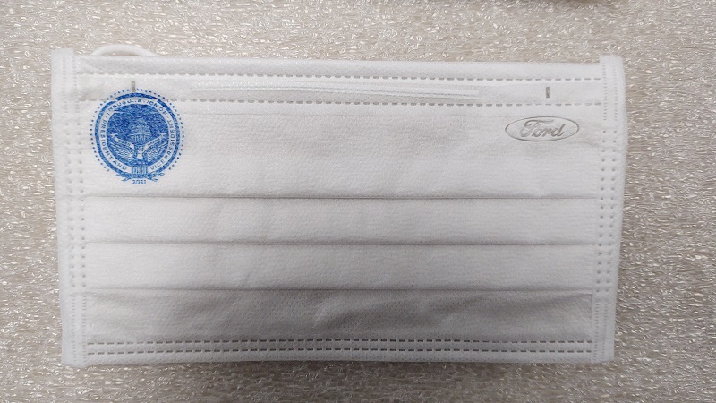 Single-Use Face Mask Manufactured for the Inaugural Ceremonies on January 20, 2021 White face mask with blue presidential insignia in one top corner and blue oval "Ford" logo in the other