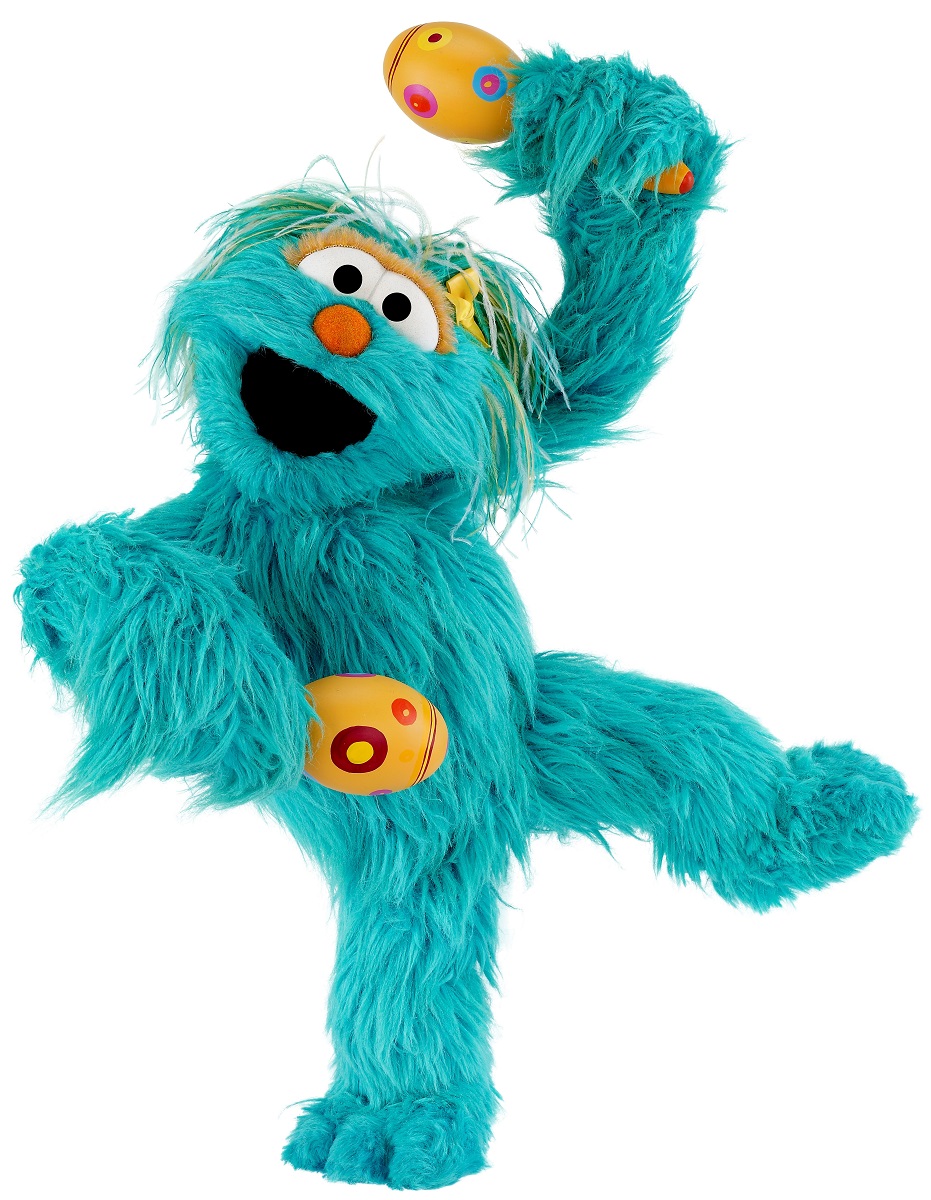 Rosita Blue furry puppet standing on one leg and holding yellow maracas
