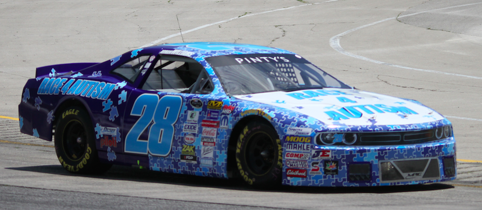 Race car in dark and light blue with a pattern of puzzle pieces, much text, and many logos