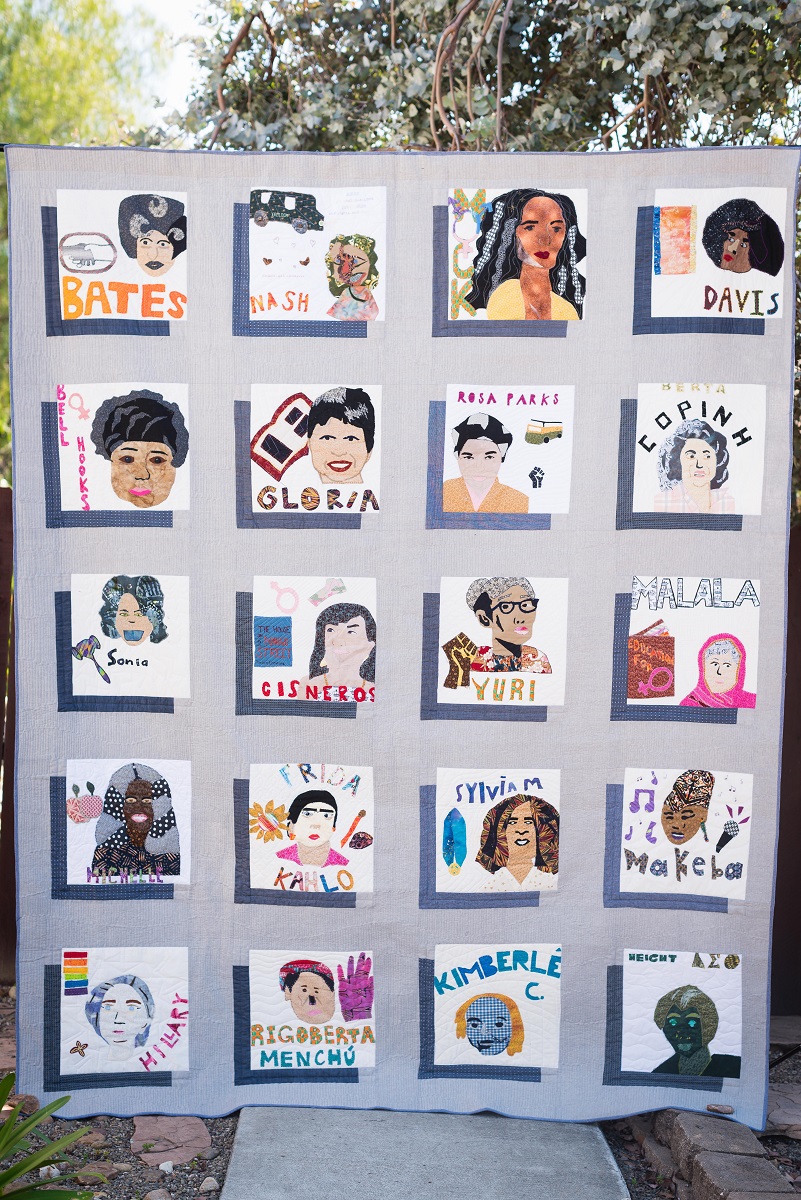 Herstory, a 2018 SJSA community quilt created by students from Alliance Gertz-Ressler High School Quilt with gray background on which there are 20 blocks, each depicting a woman's face and containing text with the woman's name